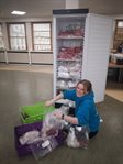 woman sitting on floor packing a food box